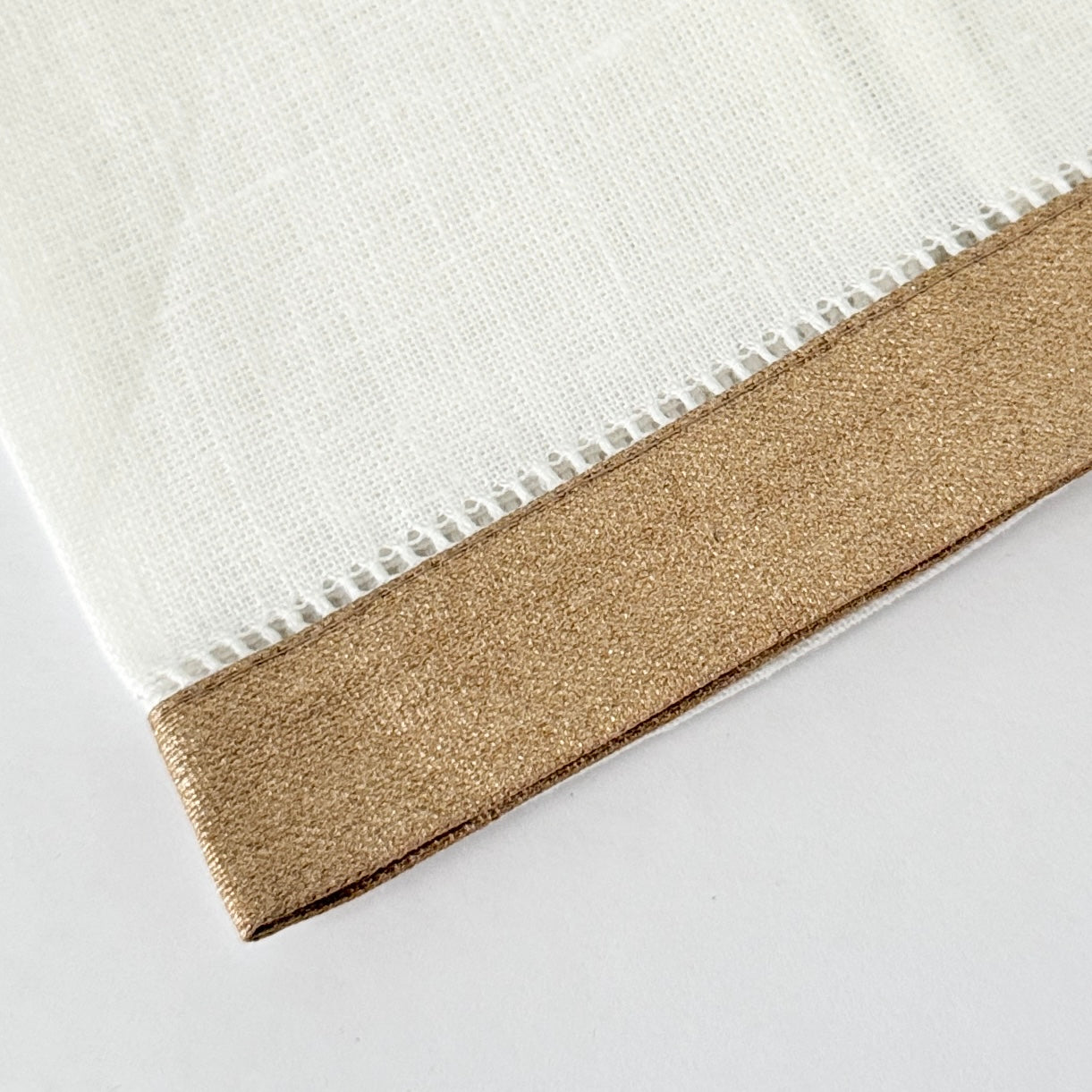 White linen guest hand towel with a colored linen hemstitch border. Featured with border color Metallic Gold. Approximately 14" x 22"