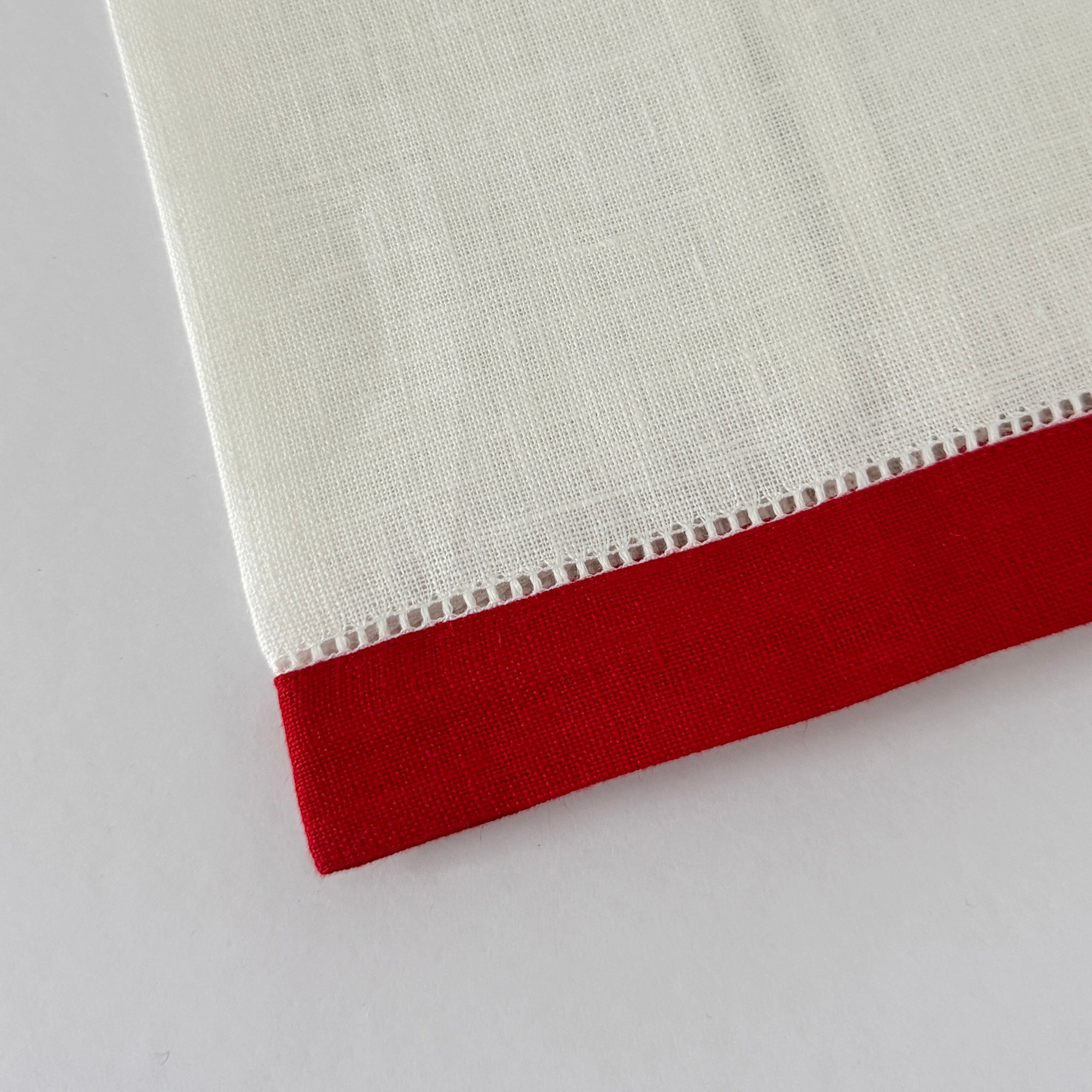 White linen guest hand towel with a colored linen hemstitch border. Featured with  border color  Merry Red. Approximately 14" x 22"