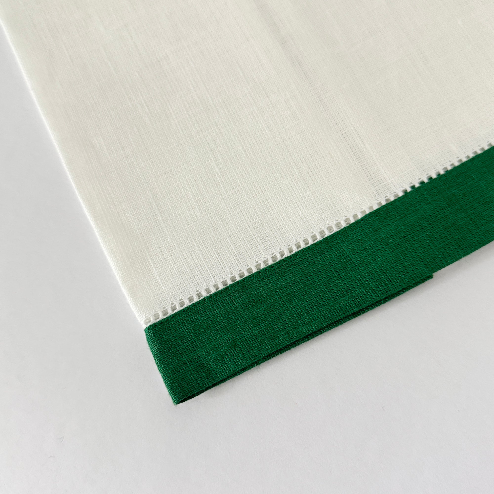 White linen guest hand towel with a colored linen hemstitch border. Featured with border color Kelly Green. Approximately 14" x 22"